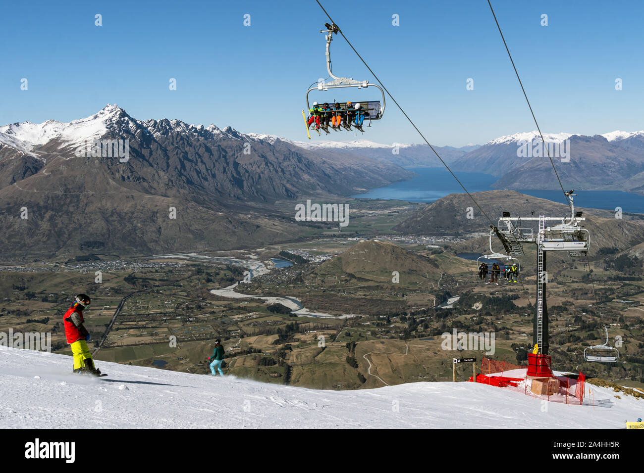 Queenstown, New Zealand September 7 2019 Skier and snowboarder ride a chairlift in the