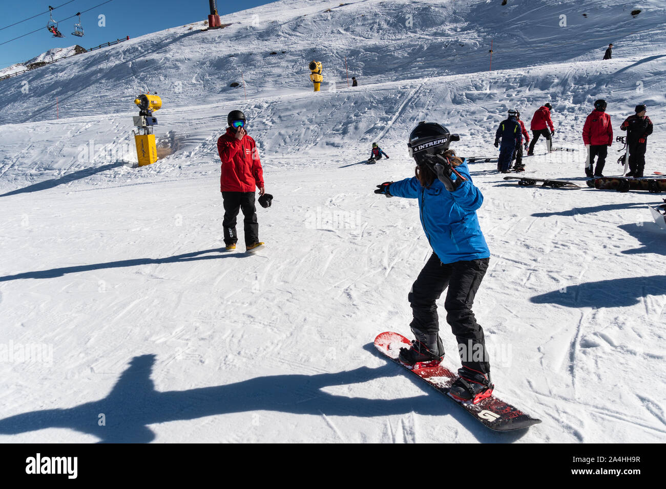 Queenstown, New Zealand - September 9 2019: A woman learn snowboarding with an instructor at the Coronet Peak ski resort in New Zealand south island Stock Photo