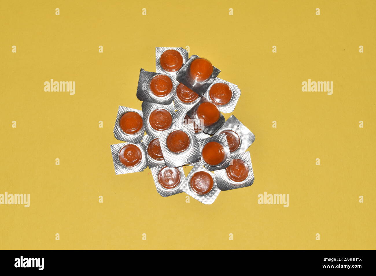 cough sore throat pastille colorful pills on background yellow Stock