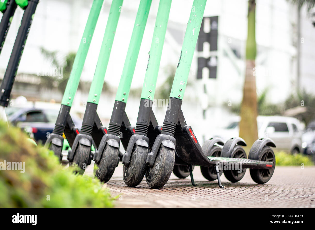Modern eco electric city scooters for rent outdoors on the sidewalk.  Alternative tourism, transportation around the city, bike replacement  service. E-scooters can be rented with an app Stock Photo - Alamy