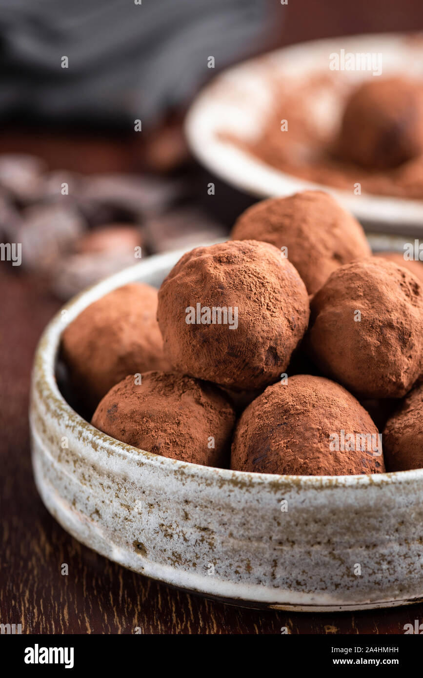 Chocolate truffles pile in a bowl covered in raw cocoa powder. Healthy