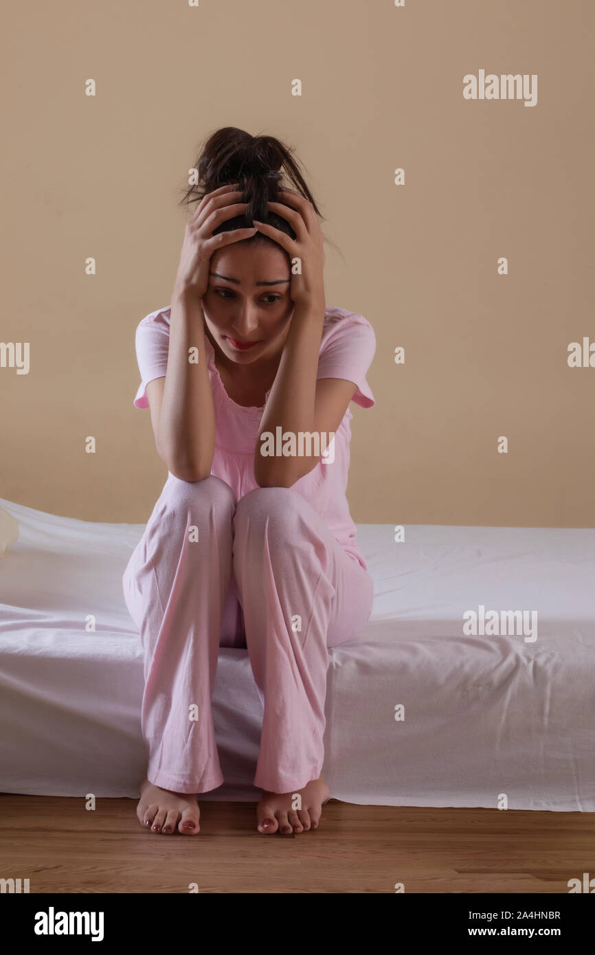 Young girl sitting alone in distress Stock Photo