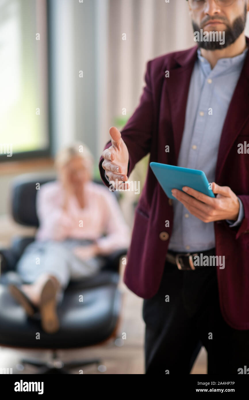 Close up of bearded psychologist reaching hand to greet patient Stock Photo