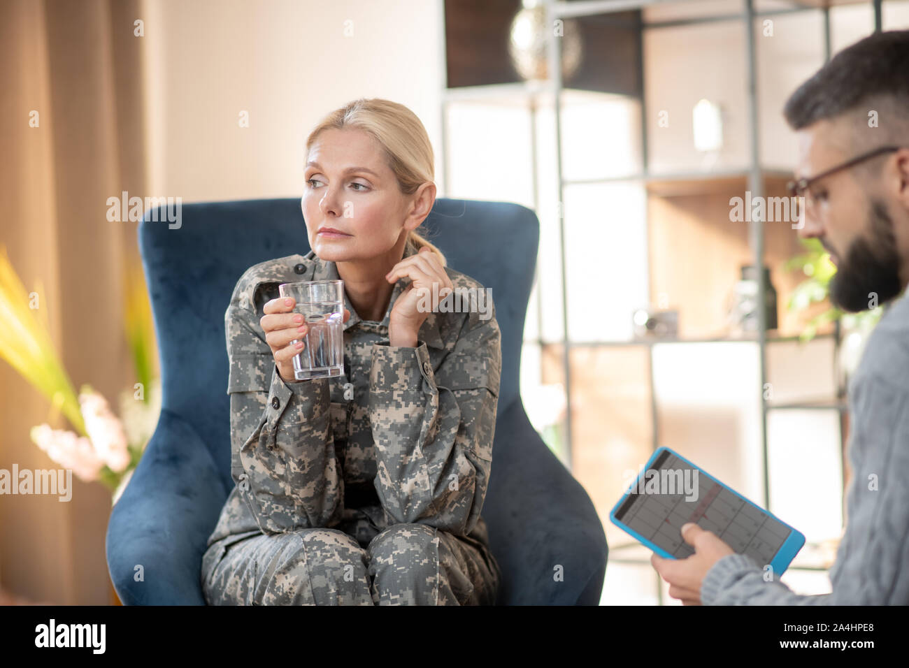 Servicewoman scheduling next appointment with young psychologist Stock Photo