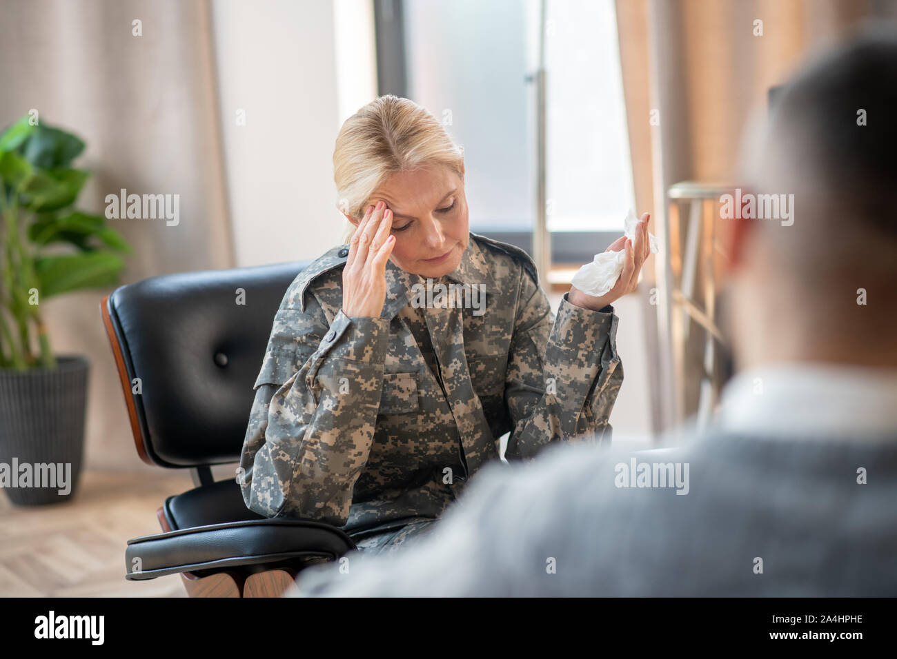 Servicewoman holding napkin and talking to psychoanalysis Stock Photo
