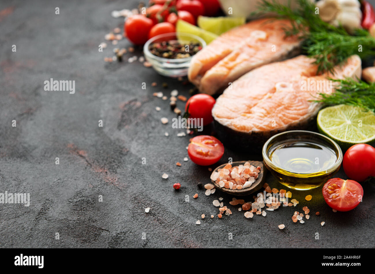 Raw salmon steaks and ingredients on a black slate board Stock Photo ...