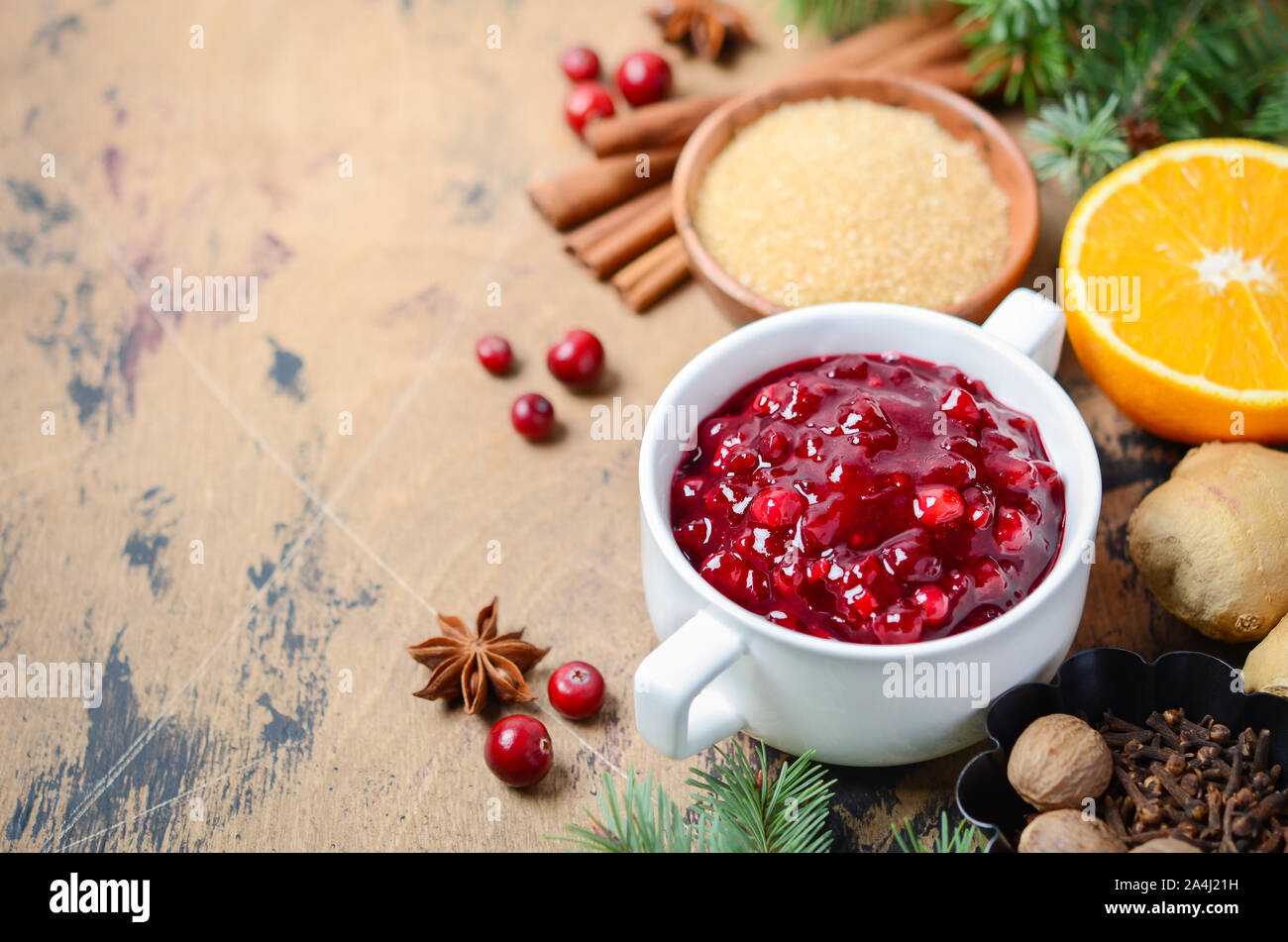 Cranberry sauce with ingredients on a wooden background. Stock Photo
