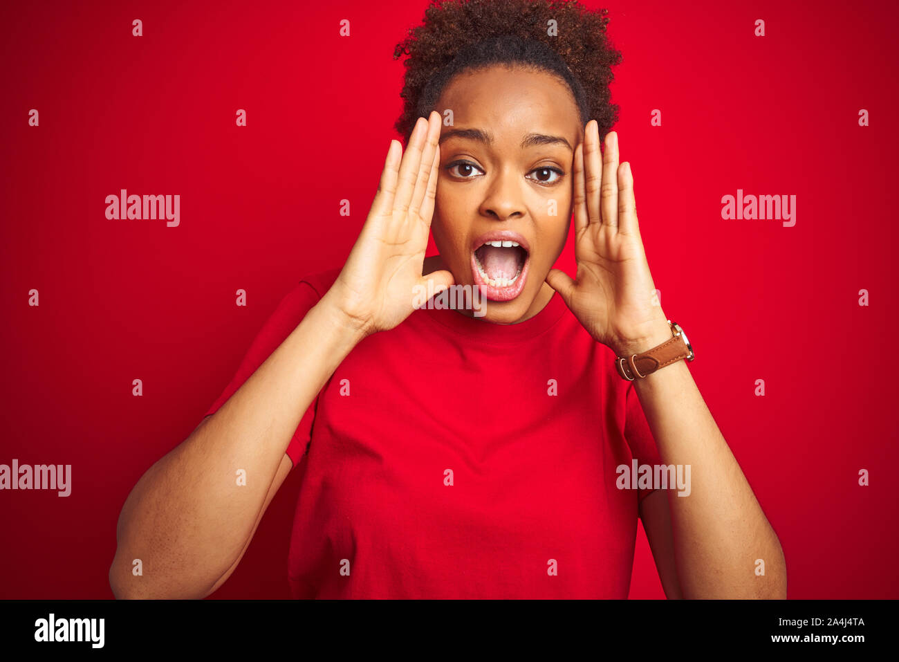 Young beautiful african american woman with afro hair over isolated red ...