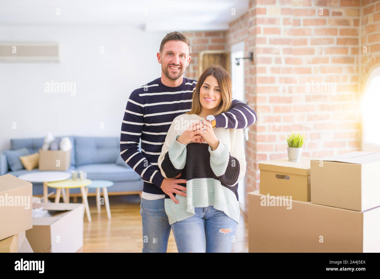 Young beautiful couple hugging at new home around cardboard boxes Stock ...