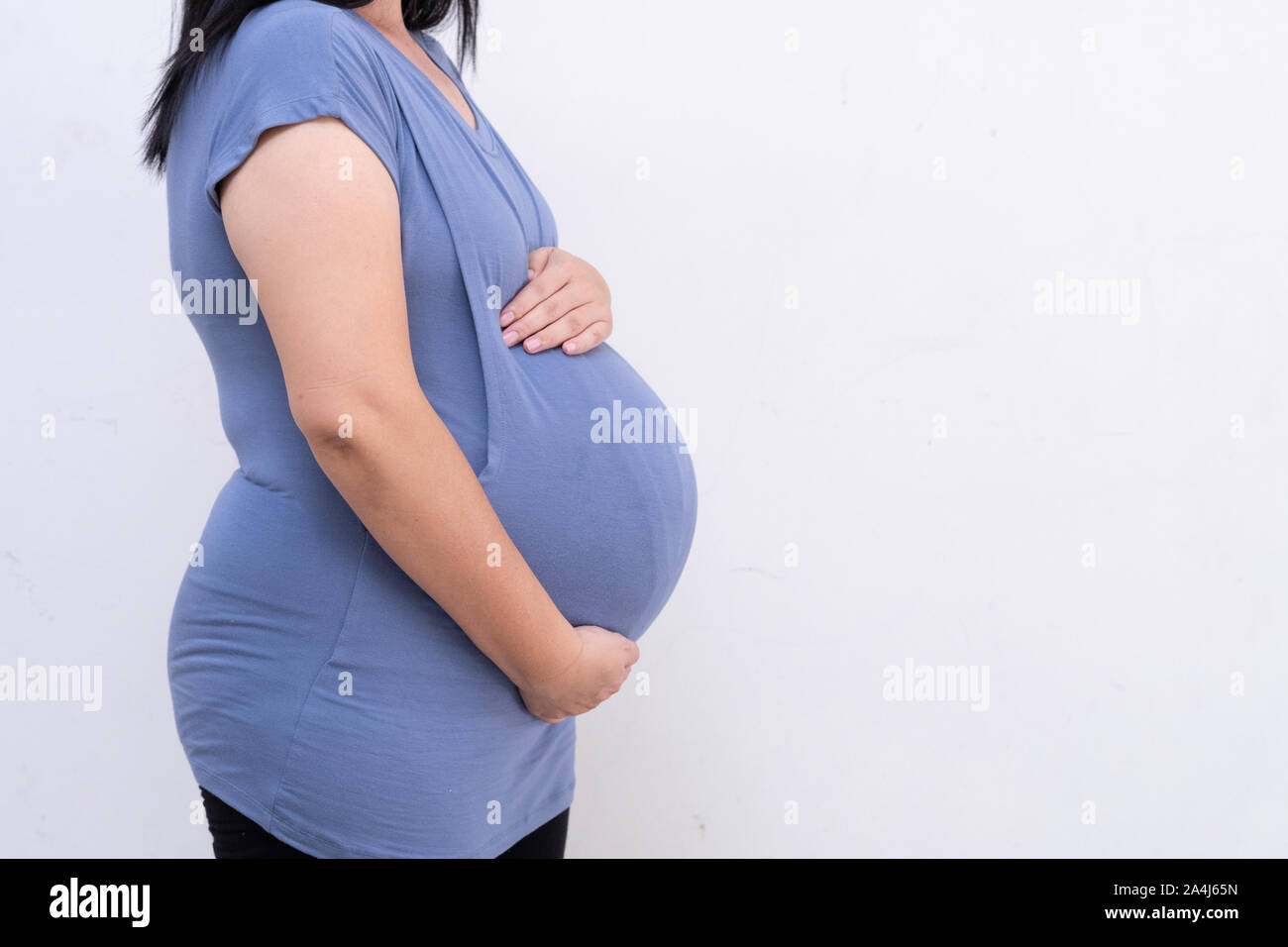 Nothing to Wear sign held by pregnant woman in the last month of pregnancy  wearing stretchy blue dress showing her bump, maternity wear and inclusive  Stock Photo - Alamy