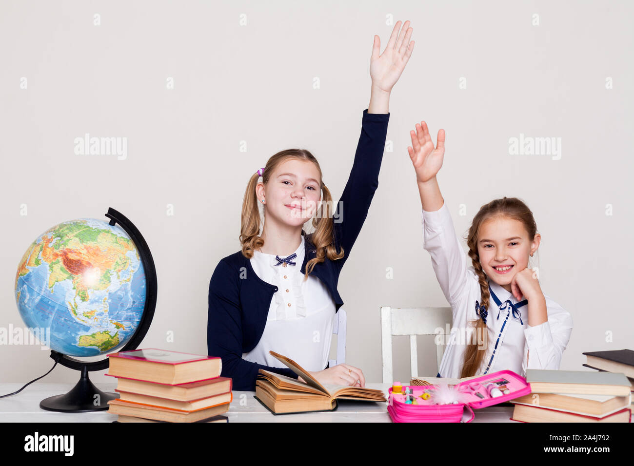 two schoolgirl girls at the desk in a geography class Stock Photo - Alamy