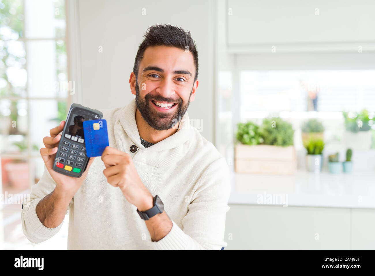 Business man smiling and holding point of sale terminal and credit card ...