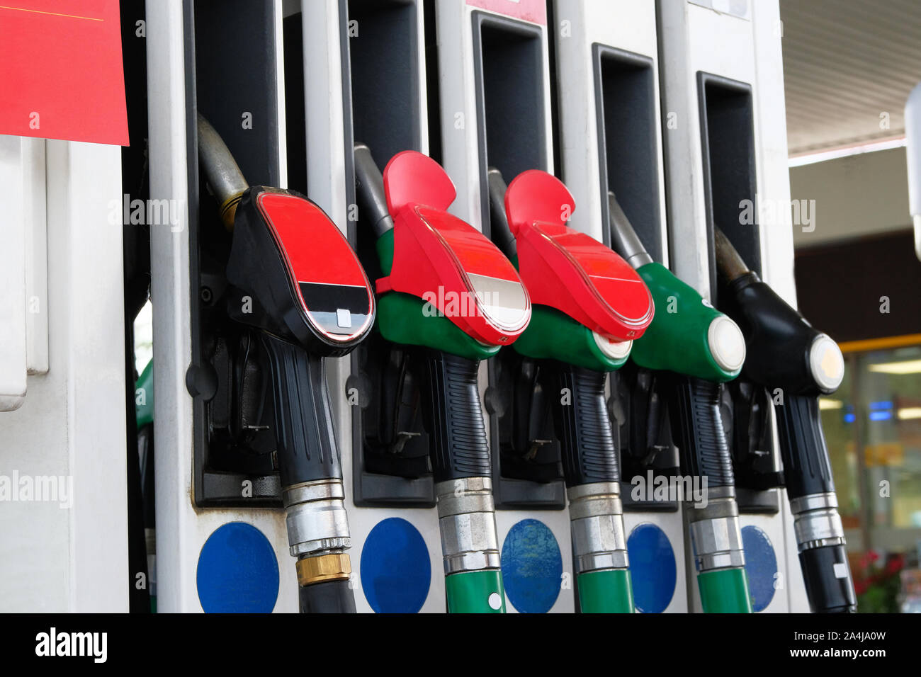 Gasoline and oil products concept. Red and black fuel pistols on fuel station. Pumping petrol at gasoline pump. Close up. Stock Photo