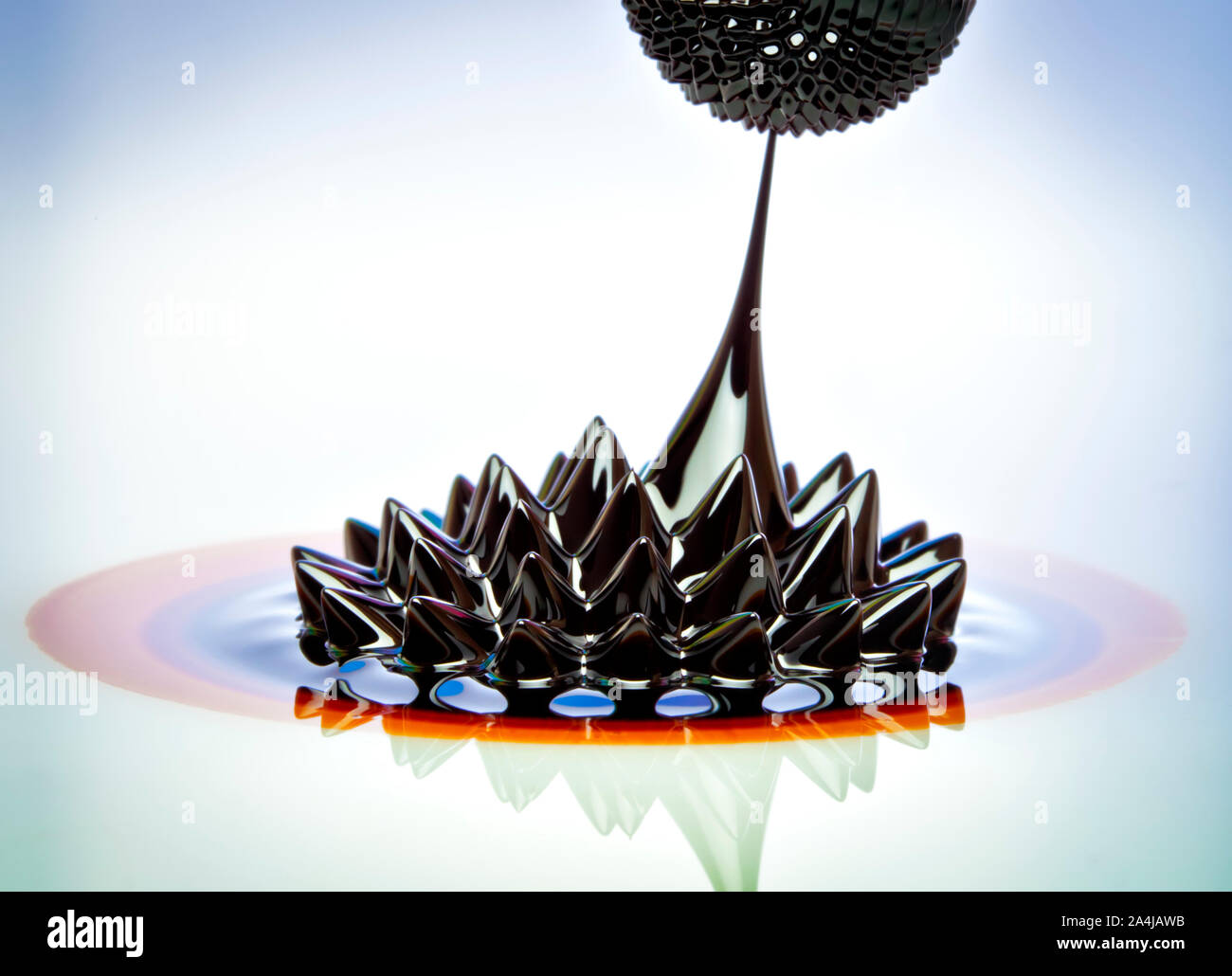 Macro photograph of Ferrofluid flowing from one magnet to another. Ferrofluid is a colloidal liquid of nanoscale particles in a carrier fluid that bec Stock Photo