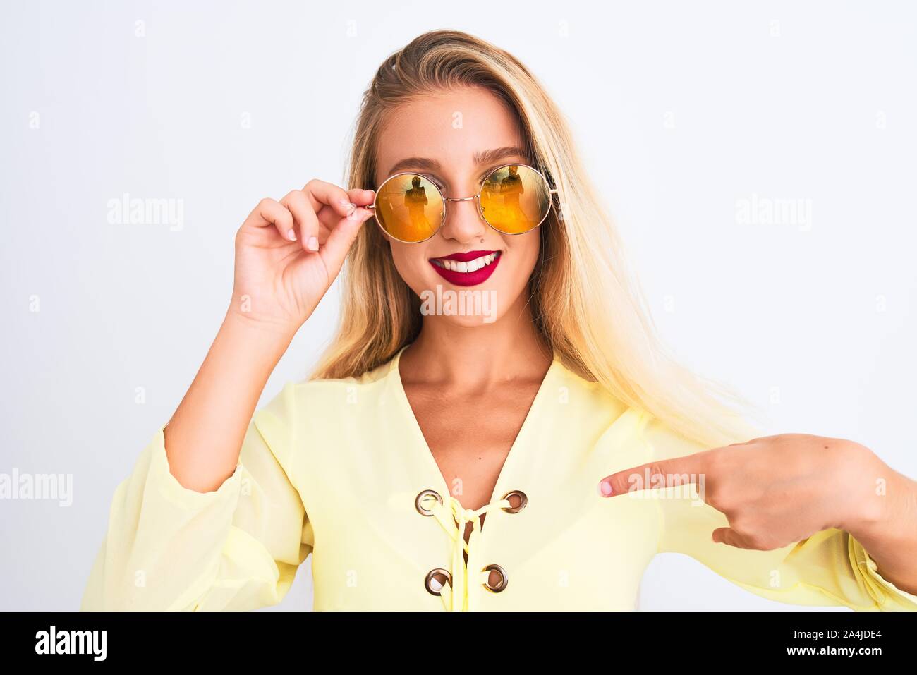 Young beautiful woman wearing yellow t-shirt and sunglasses over ...
