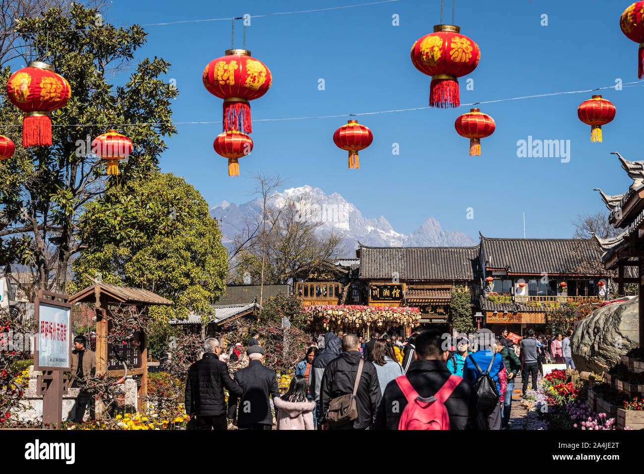 Lijiang, China - February 14 2019: Chinese tourists wander the street of the famous Lijiang old town in Yunnan province with the Yulong snow mountain Stock Photo