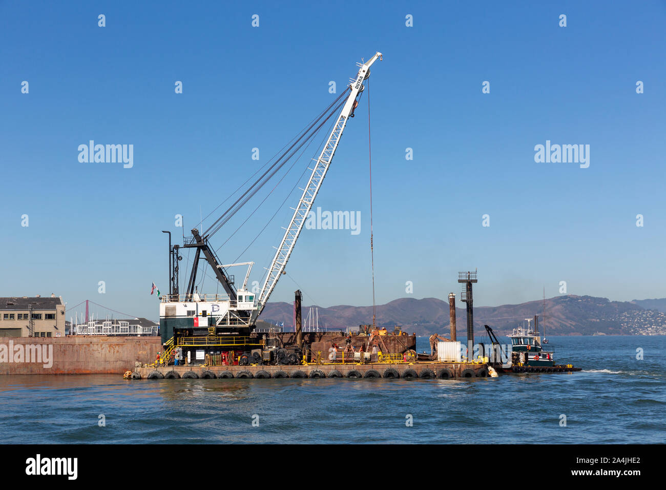 SAN FRANCISCO, USA - OCTOBER  2, 2019 : Dredging crane and barge at the end of Pier 35 in San Francisco bay. Stock Photo