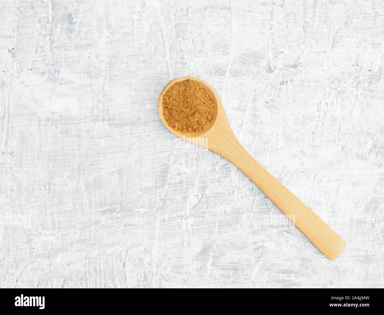 Spices help maintain good health and improve appetite, top view on white concrete background. Masala in wooden spoon. Modern apothecary, naturopathy a Stock Photo