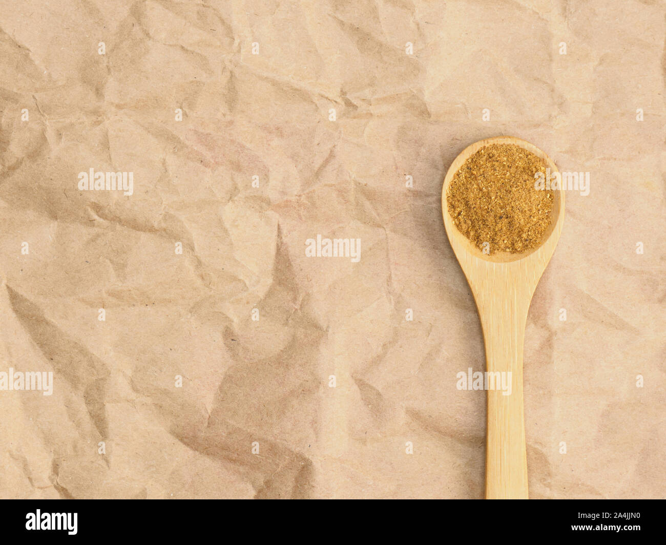 Spices help maintain good health and improve appetite, top view on craft paper background. Masala in wooden spoon. Modern apothecary, naturopathy and Stock Photo