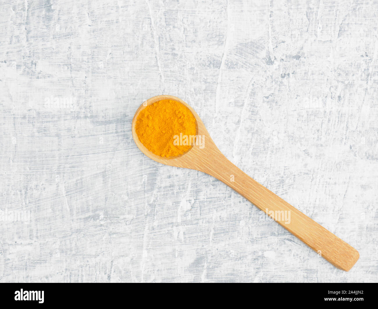 Spices help maintain good health and improve appetite, top view on white concrete background. Turmeric in wooden spoon. Modern apothecary, naturopathy Stock Photo