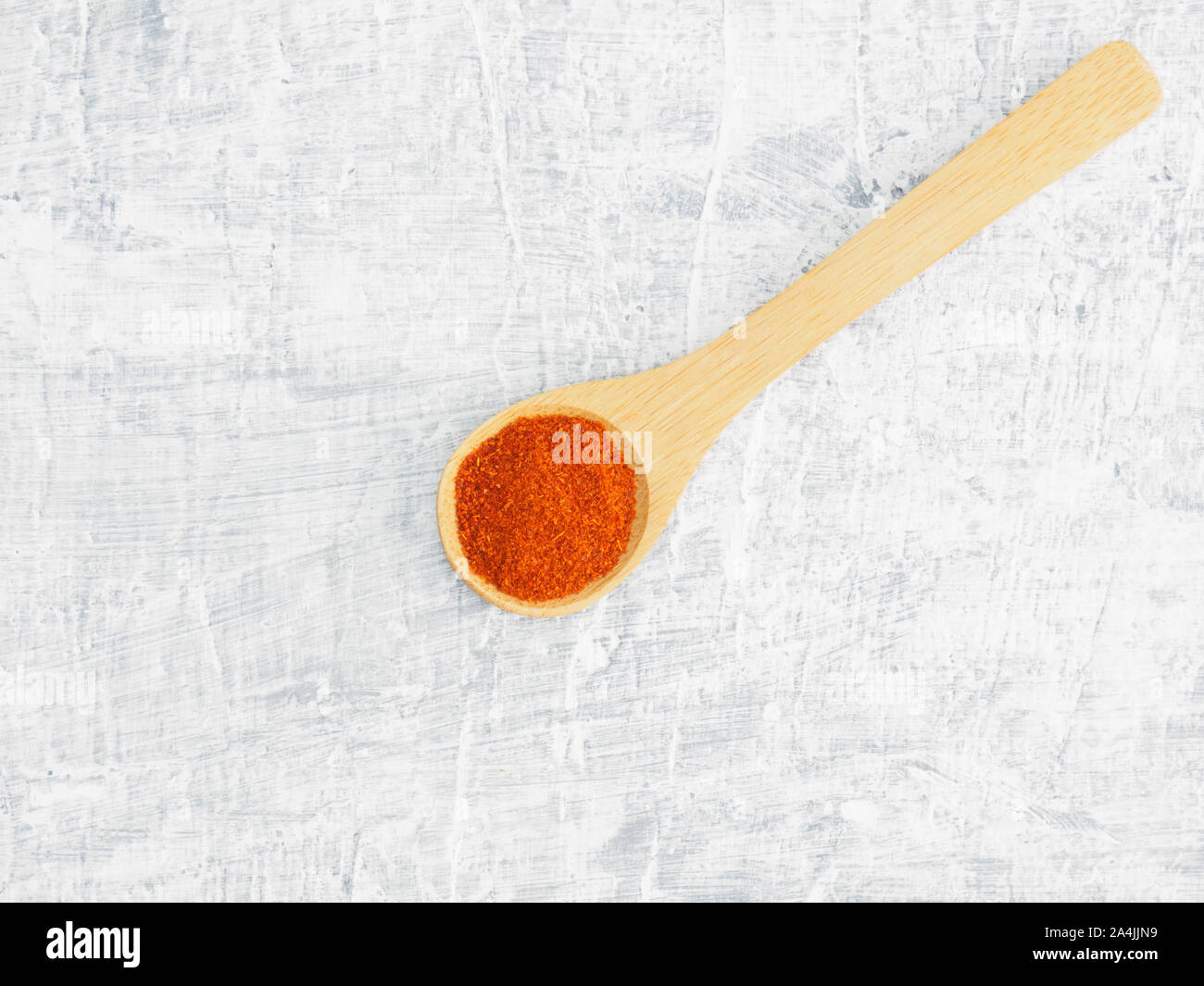 Spices help maintain good health and improve appetite, top view on white concrete background. Red chili pepper in wooden spoon. Modern apothecary, nat Stock Photo