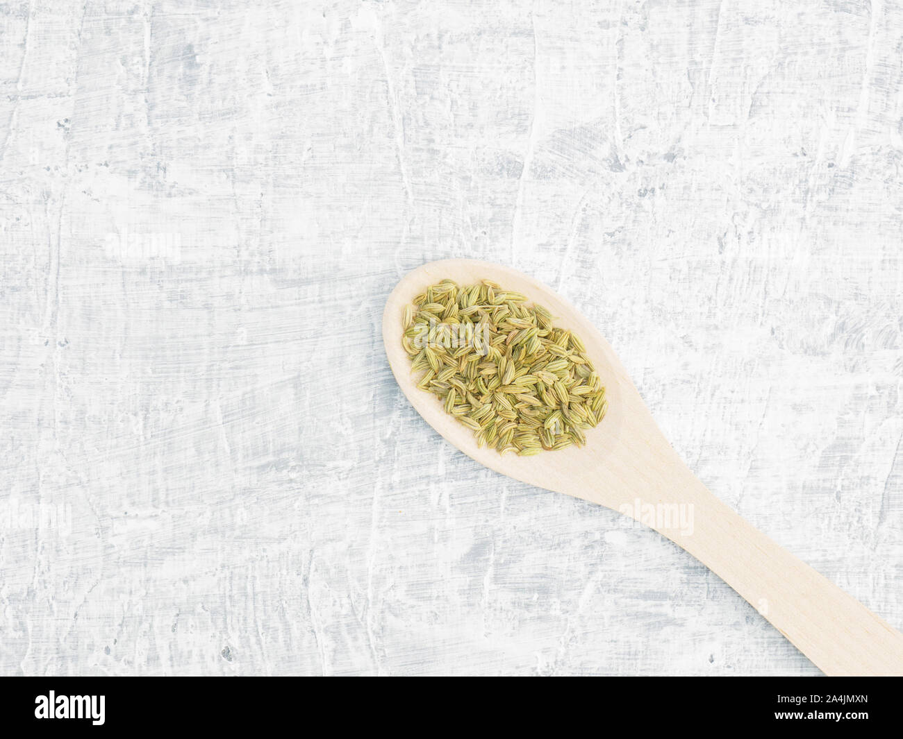 Spices and herbs help maintain good health and improve appetite, top view on white concrete background. Fennel in wooden spoon. Modern apothecary, nat Stock Photo