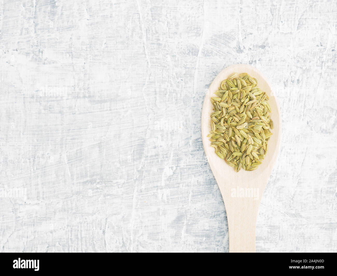 Spices and herbs help maintain good health and improve appetite, top view on white concrete background. Fennel in wooden spoon. Modern apothecary, nat Stock Photo