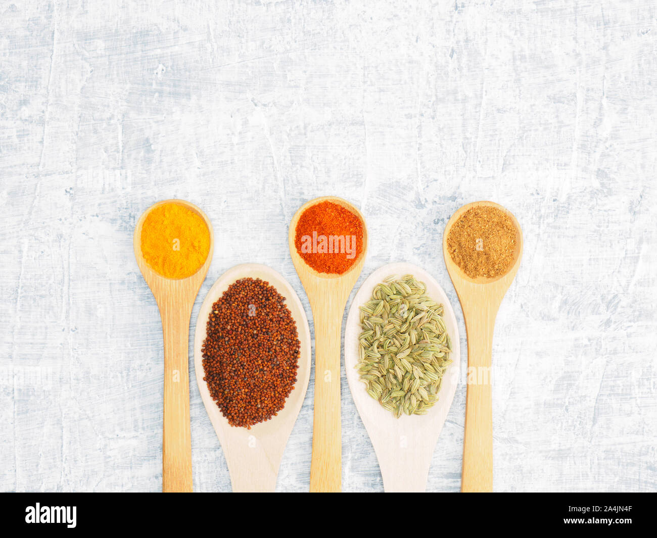 Spices and herbs set on concrete background in wooden spoon. Modern apothecary, naturopathy and ayurveda concept. Stock Photo