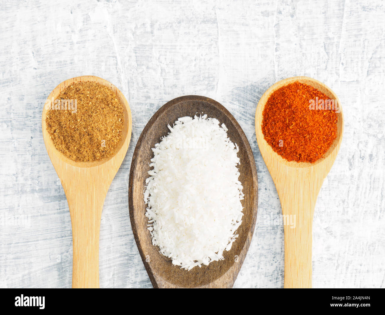 Spices and herbs set on concrete background in wooden spoon. Masala, mustard, chili pepper. Modern apothecary, naturopathy and ayurveda concept. Stock Photo