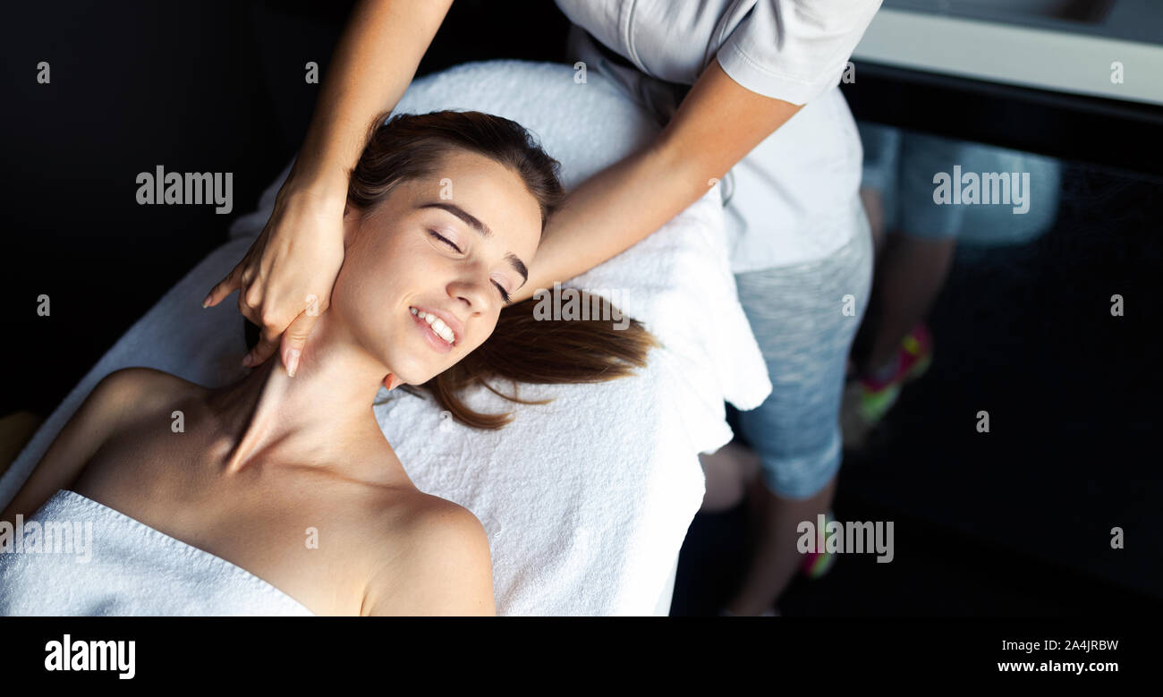 Masseur doing massage on female body in the spa salon. Beauty treatment concept. Stock Photo