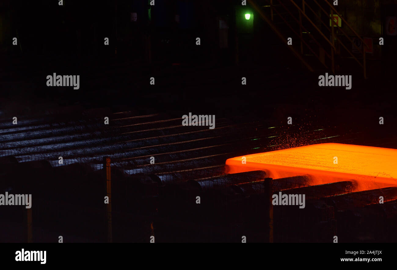 Hot steel plate on conveyor inside of steel plant Stock Photo