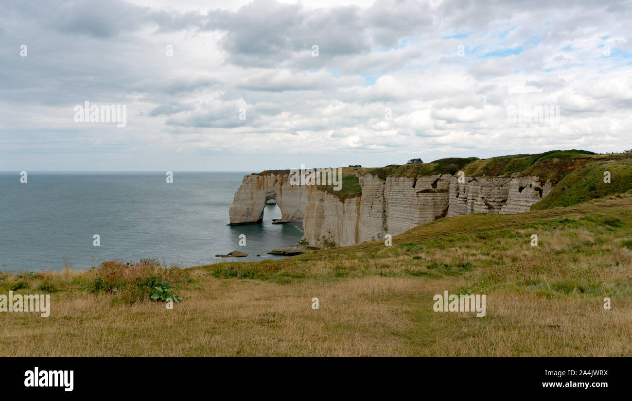 A view of the ocean and wild coast with green fields and jagged cliffs Stock Photo