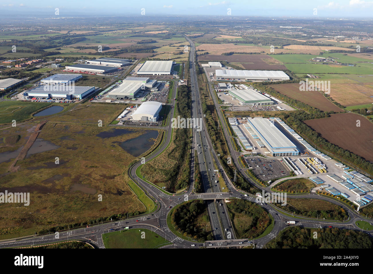 aerial view of new warehouses & logistics hubs on the M62 motorway looking west from junction 8, Burtonwood, Warrington, Cheshire, UK Stock Photo