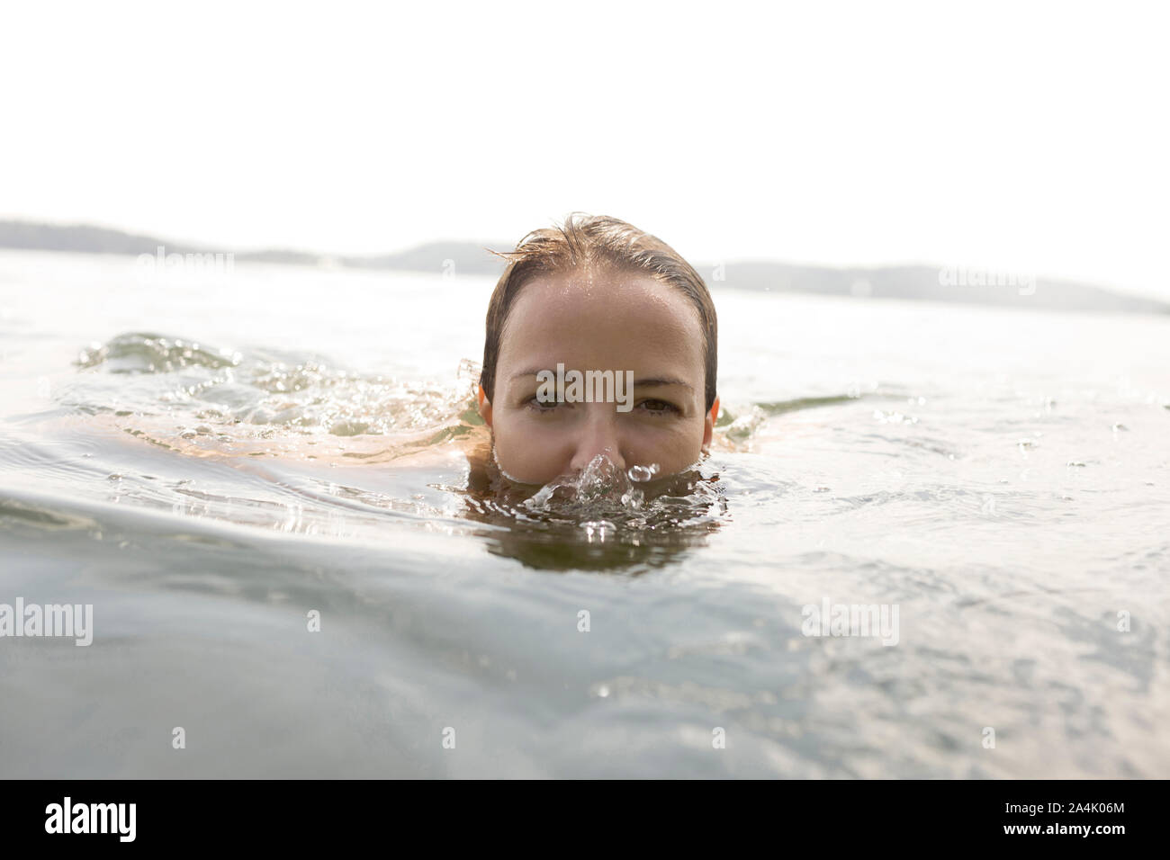 Portrait Of A Mid Adult Woman Swimming In A Lake Stock Photo