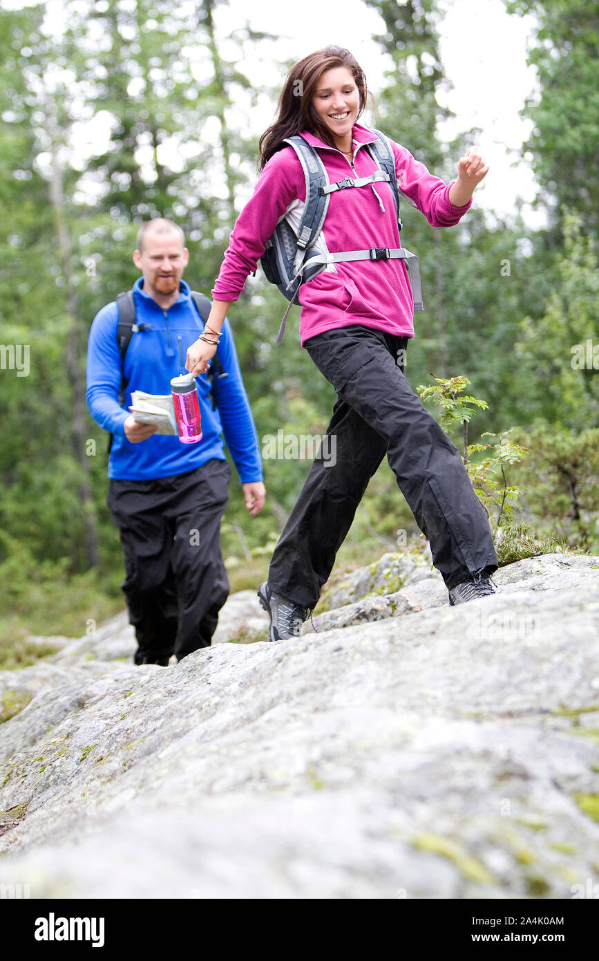 Couple Hiking On Mountain Trail, Man Holding Map At Background Stock Photo
