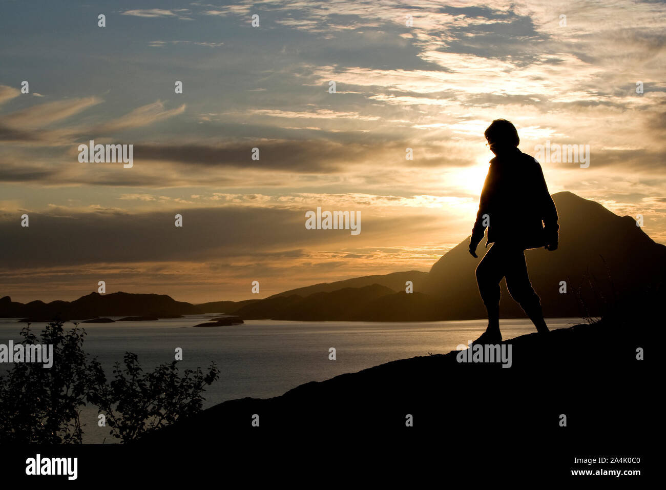 Silhouette of person in front of lake Stock Photo