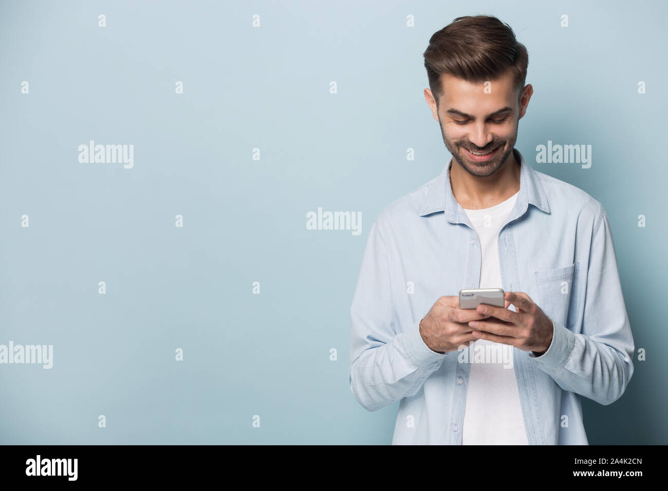 Smiling man using modern smartphone with wireless internet Stock Photo
