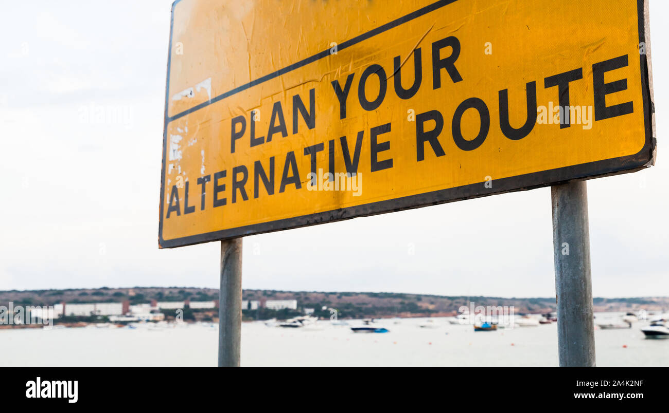 Plan your alternative route. Standard yellow sign with text standing on a sea coast Stock Photo