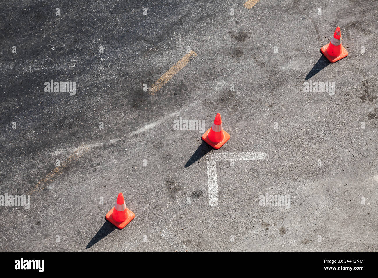 Three red warning road cones stand in line on an urban ground Stock Photo