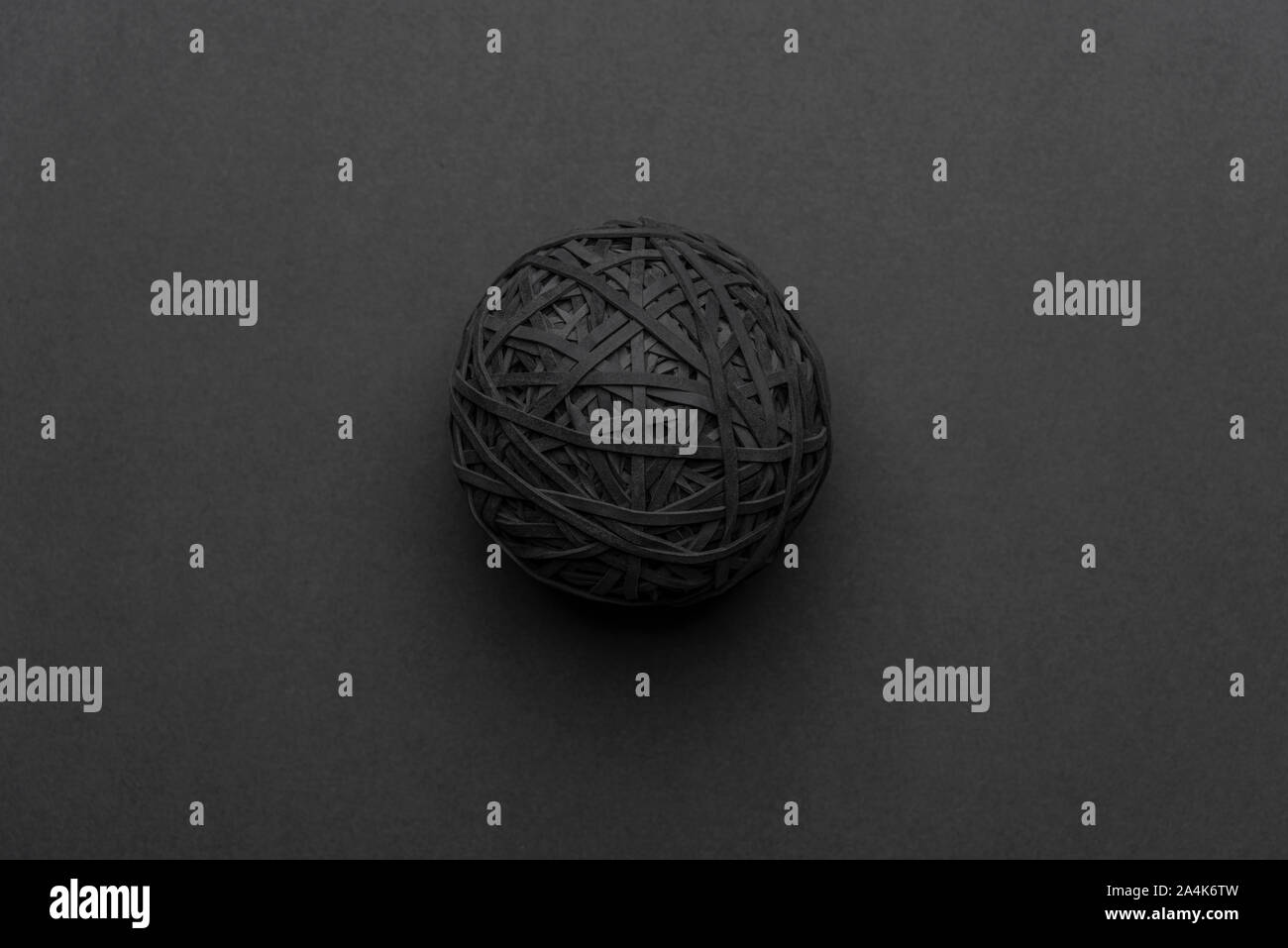 Black rubber band ball isolated on a grey background. 14.10.2019 Please credit: Phillip Roberts Stock Photo