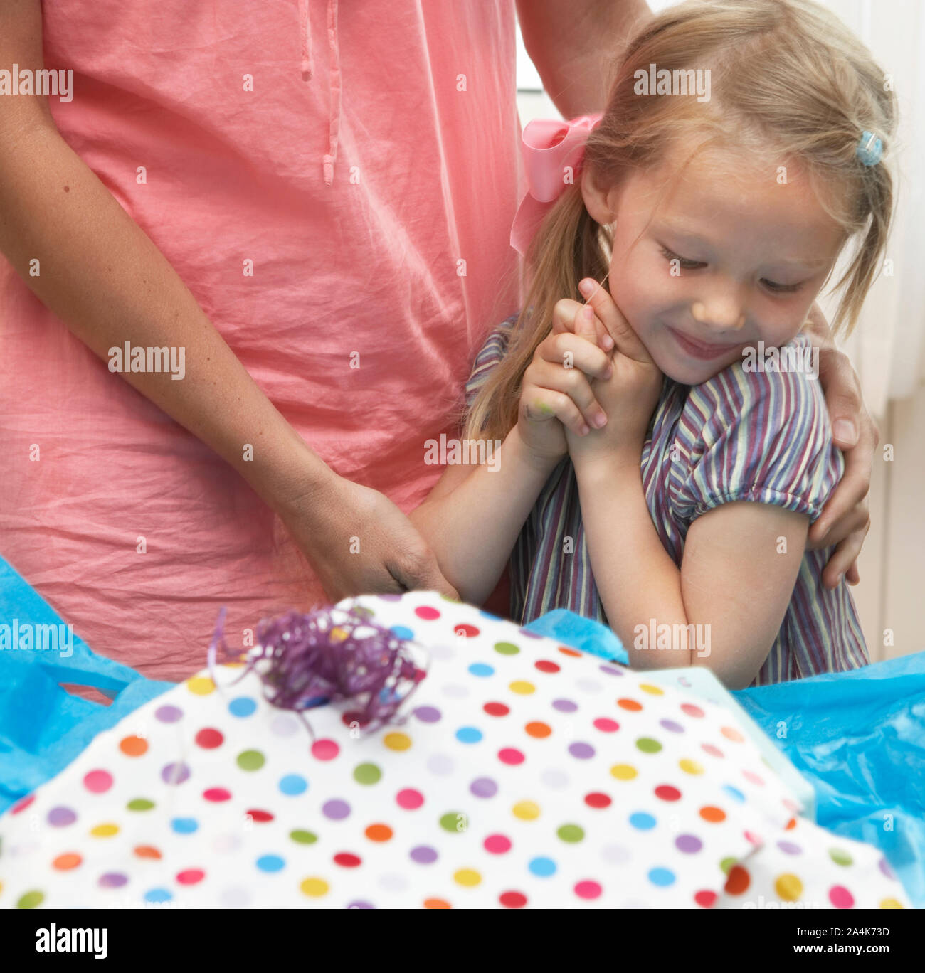 Birthday girl unwrapping presents - wrapping paper - expectations - exited - grateful Stock Photo