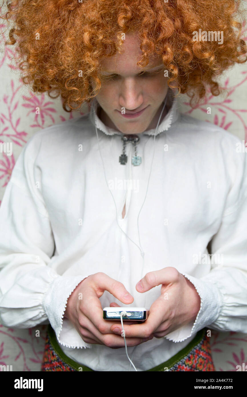 Red haired guy listening to music on an Ipod - looking down Stock Photo