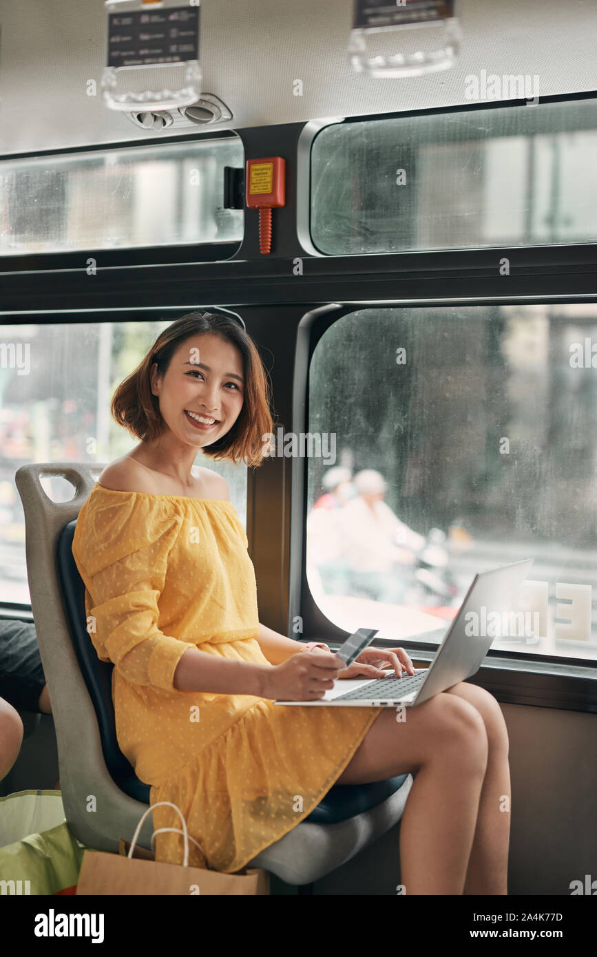 Young businesswoman on a business travel. Working on the bus using her laptop. Stock Photo