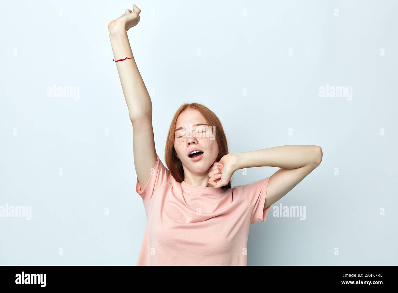 attractive tired woman stretching back, tired and relaxed, sleepy and yawning for early morning, close up portrait, isolated white background, studio Stock Photo