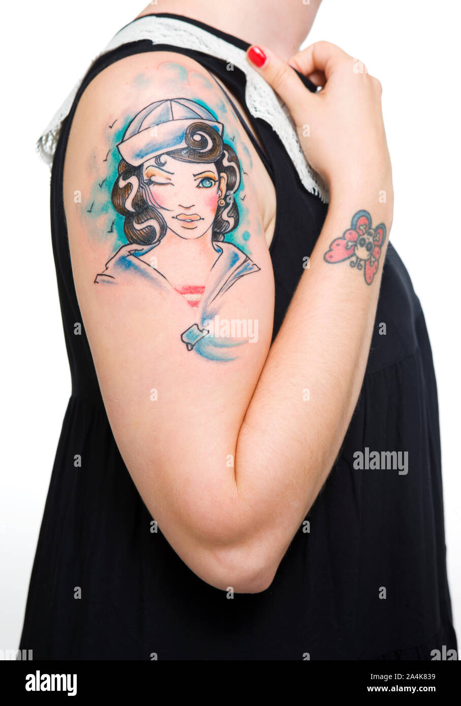 Woman with tattoo on arm. Motive female sailor blinking eye. Stock Photo