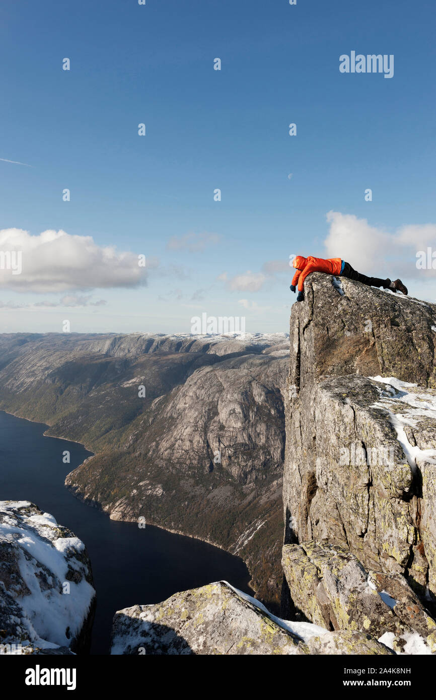 Man Lying On Edge Of Mountain, Kjerag, Lysefjorden Stock Photo
