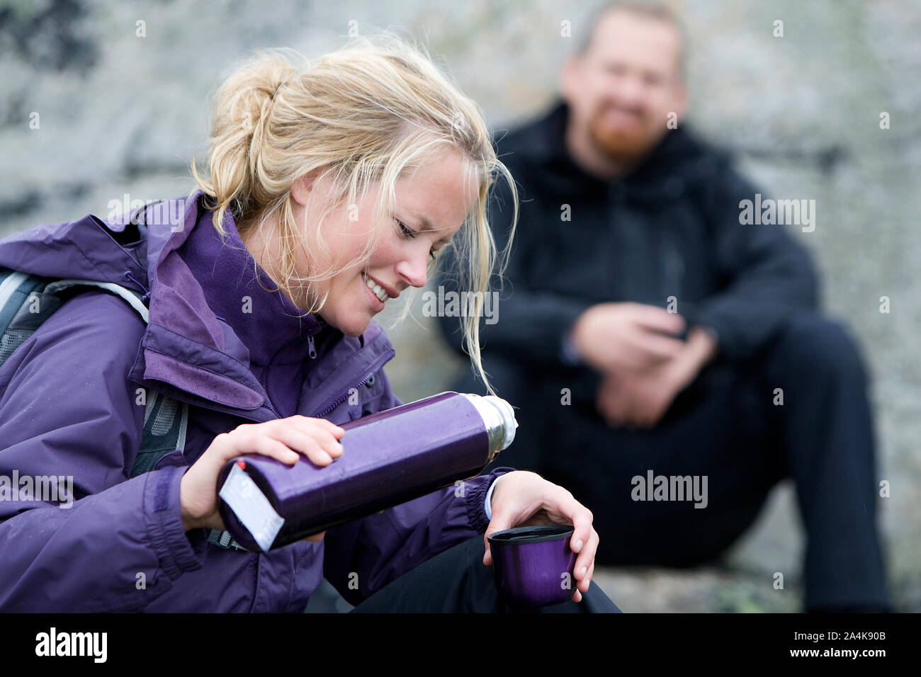 Portrait Of Woman Pouring Coffee And Man Sitting At Background, Outdoors Stock Photo