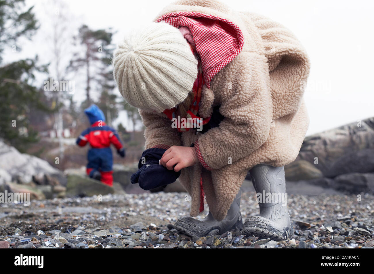 Girl picking shells and collecting stones on the beach Stock Photo - Alamy