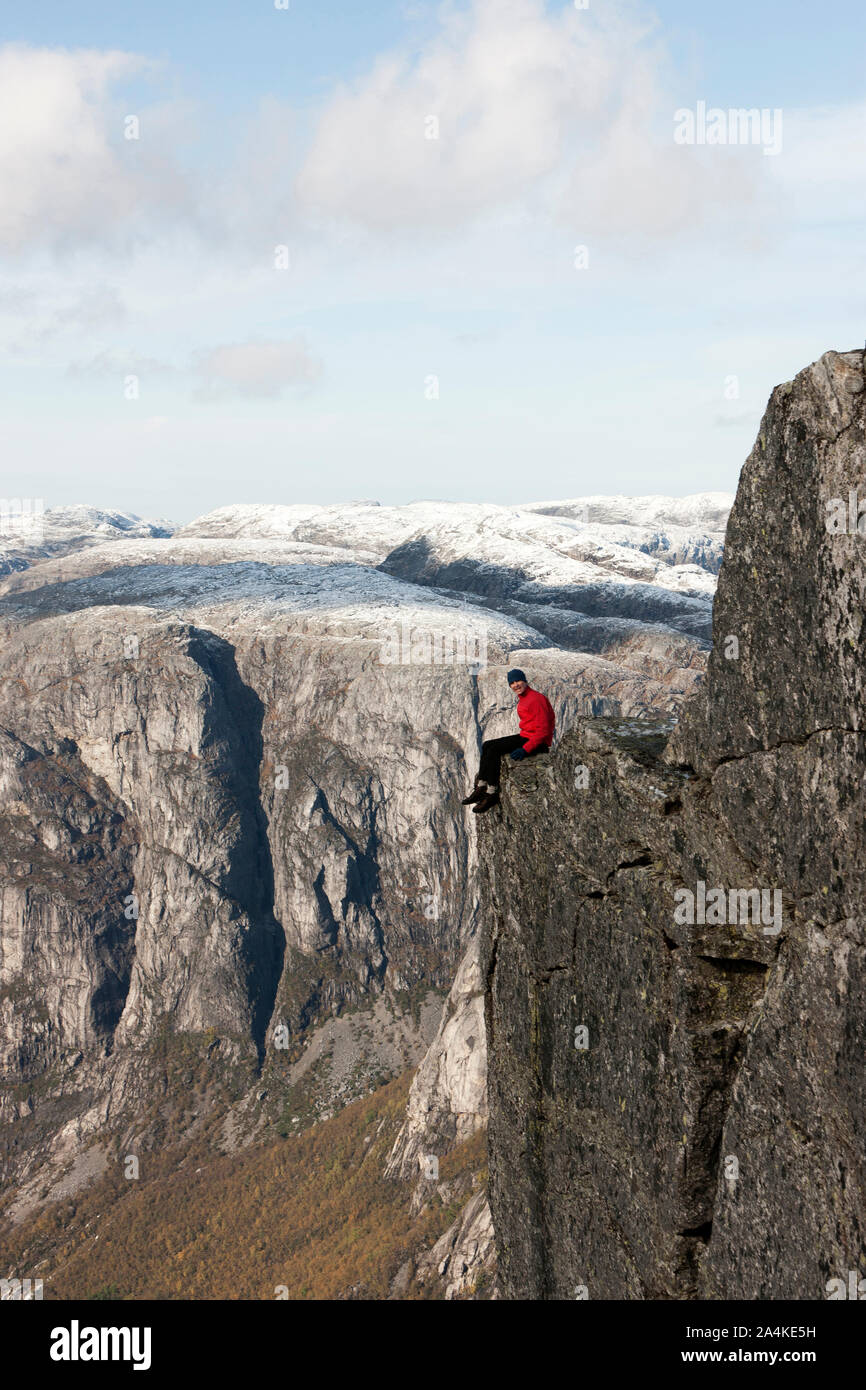 Man Sitting On Edge Of Mountain - Kjerag, Lysefjorden, Stock Photo