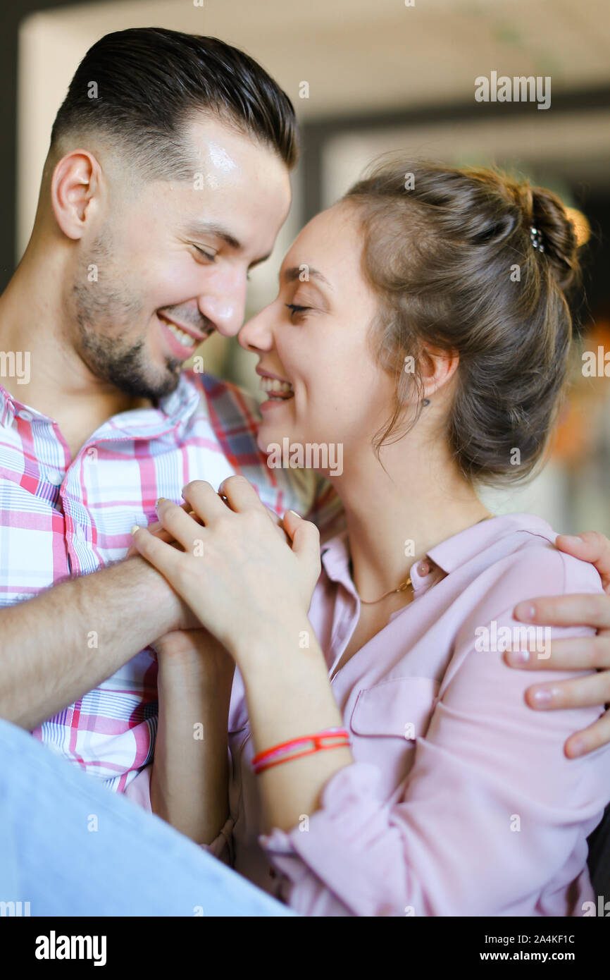 Young girl hugging boyfriend at home and smiling Stock Photo - Alamy